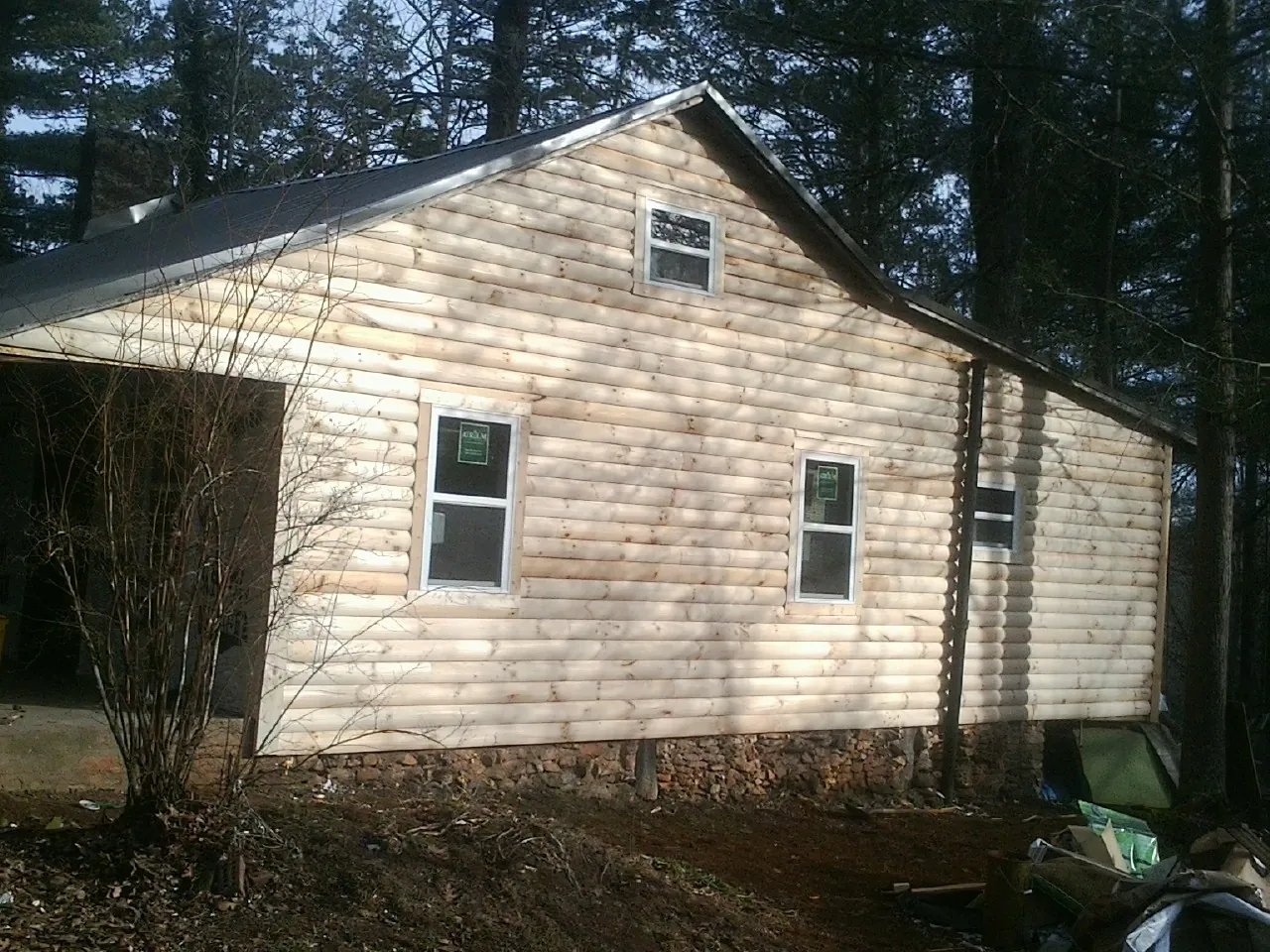 New log siding and dark metal roofing on a gable end in Linwood